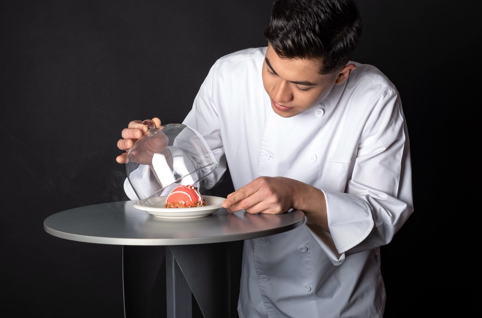 Chef presentando un plato bajo campana